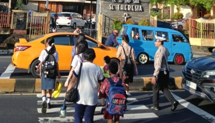 Humanis di Pagi Hari, Personel Polsek Malalayang Bantu Pelajar Menyeberang dan Urai Kemacetan